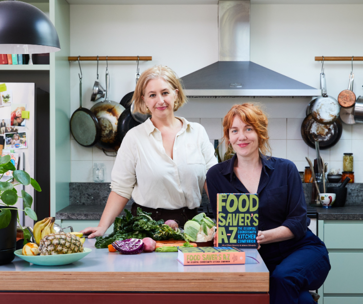 Two women in a kitchen with book 'Food Savers A-Z'.